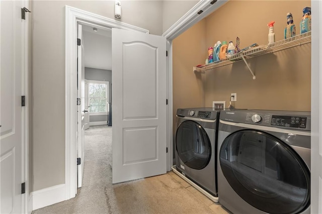 clothes washing area featuring light colored carpet and independent washer and dryer