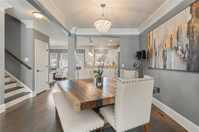 dining area with dark hardwood / wood-style flooring, ornamental molding, and a chandelier