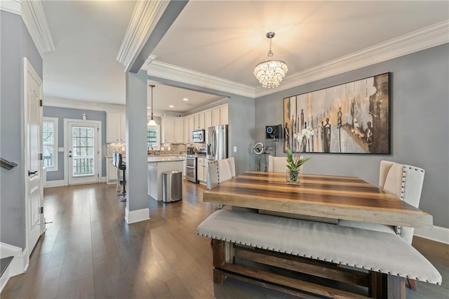 dining area featuring dark hardwood / wood-style flooring, ornamental molding, and an inviting chandelier