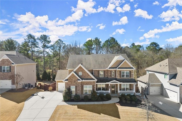 view of front facade featuring covered porch, driveway, brick siding, and a garage