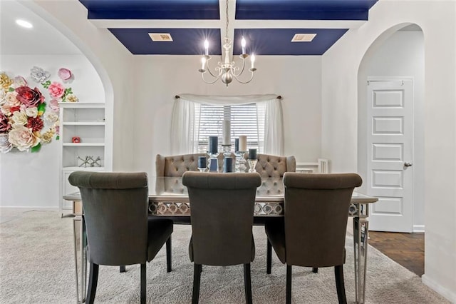 dining space featuring beamed ceiling, carpet flooring, coffered ceiling, and a notable chandelier