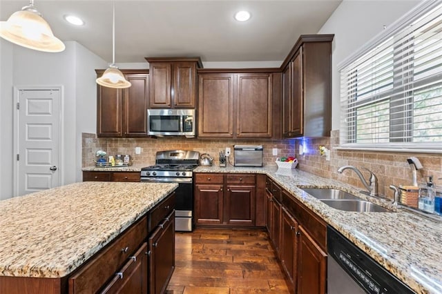 kitchen featuring hanging light fixtures, dark hardwood / wood-style floors, sink, and appliances with stainless steel finishes