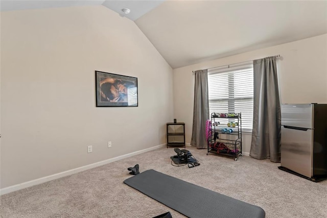 exercise area with light carpet and vaulted ceiling