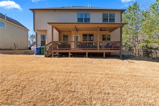 back of property featuring a wooden deck, ceiling fan, and a lawn