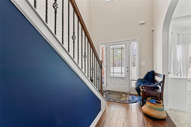 entrance foyer featuring hardwood / wood-style flooring and a towering ceiling