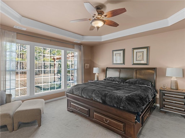 bedroom featuring light carpet, a raised ceiling, and crown molding