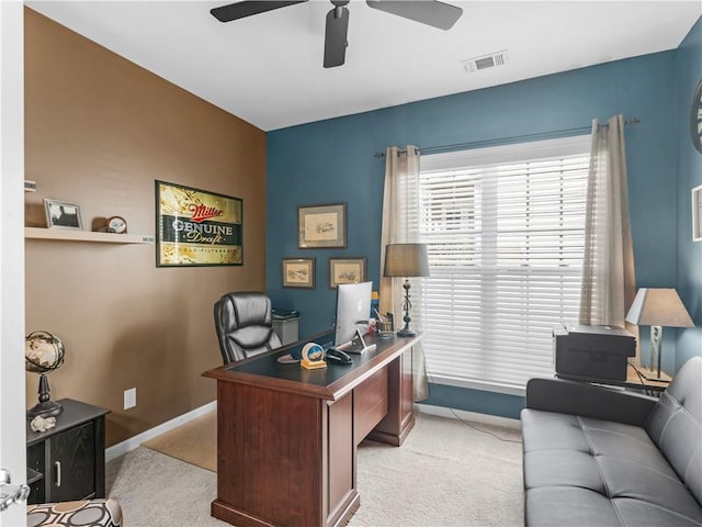 office area featuring a ceiling fan, light colored carpet, visible vents, and baseboards