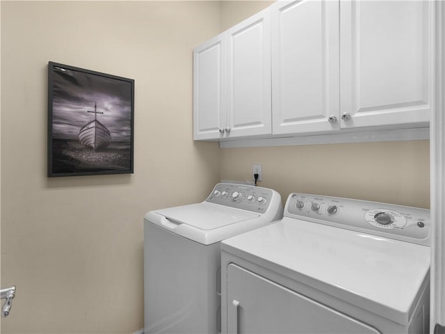 laundry area with washing machine and clothes dryer and cabinet space