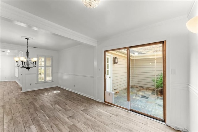 unfurnished dining area with ornamental molding, a chandelier, and light hardwood / wood-style floors