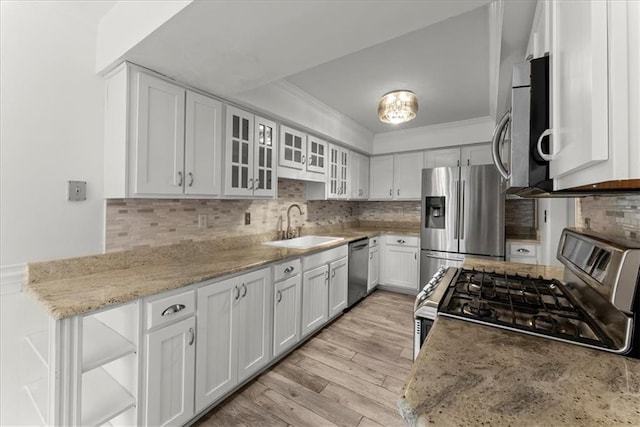 kitchen with crown molding, appliances with stainless steel finishes, white cabinetry, light stone countertops, and light wood-type flooring