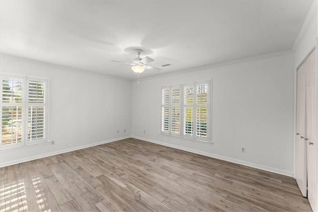 spare room with crown molding, a healthy amount of sunlight, and hardwood / wood-style floors