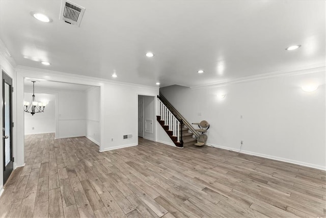 basement with an inviting chandelier, ornamental molding, and light wood-type flooring