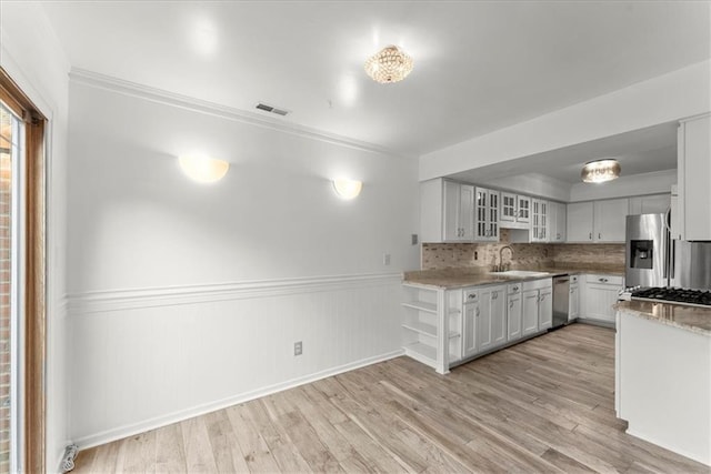 kitchen with sink, light hardwood / wood-style flooring, white cabinets, and appliances with stainless steel finishes