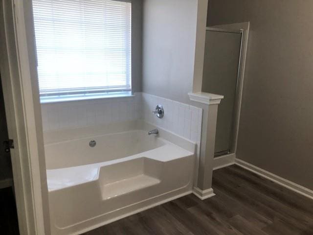 bathroom with hardwood / wood-style flooring and separate shower and tub