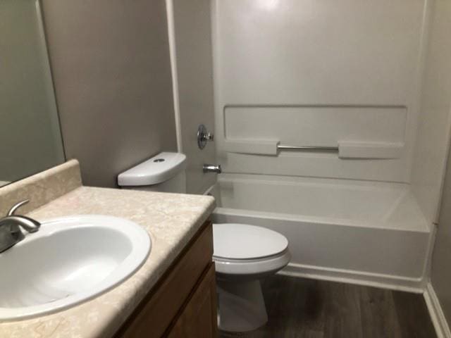 full bathroom with wood-type flooring, shower / washtub combination, vanity, and toilet