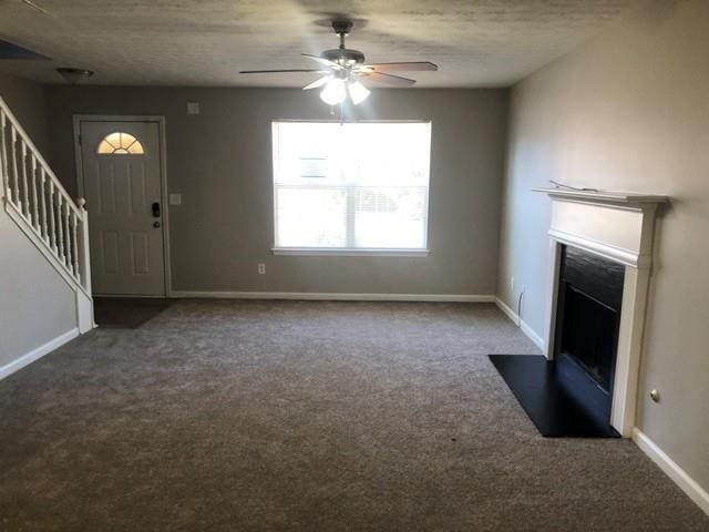 unfurnished living room featuring carpet floors, a textured ceiling, and ceiling fan