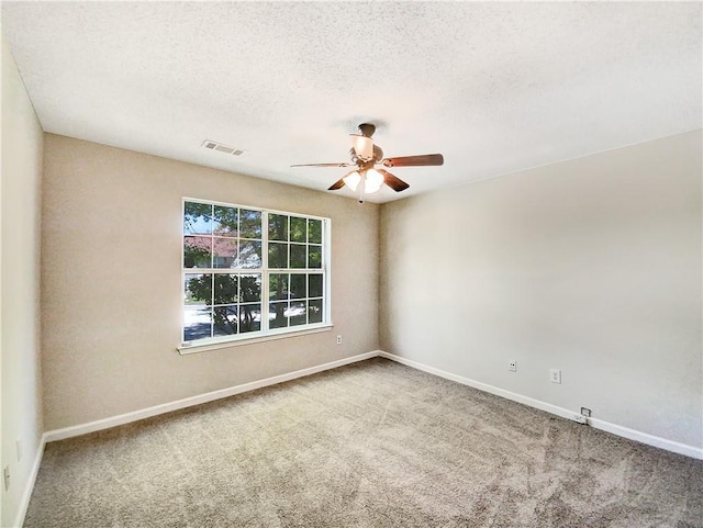 spare room featuring carpet flooring and a textured ceiling