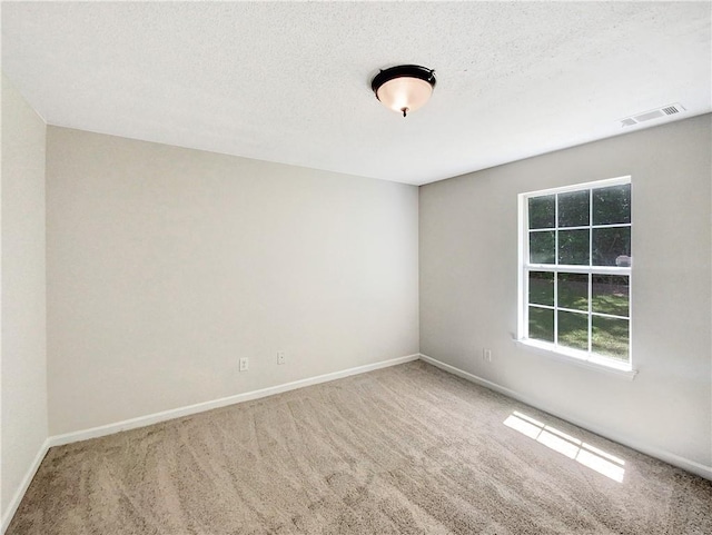 carpeted spare room with a textured ceiling