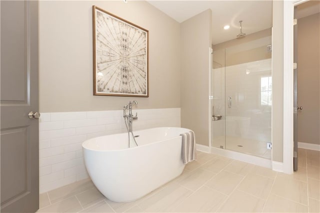 4923 Sudbrook Way Unit 233, Peachtree Corners, GA 30092 - bathroom featuring a shower stall, a freestanding bath, tile walls, wainscoting, and tile patterned flooring