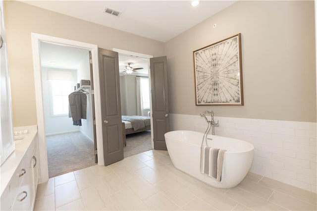 4923 Sudbrook Way Unit 233, Peachtree Corners, GA 30092 - ensuite bathroom with a soaking tub, vanity, tile walls, ceiling fan, and wainscoting