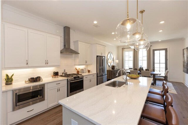 4923 Sudbrook Way Unit 233, Peachtree Corners, GA 30092 - kitchen featuring stainless steel appliances, wall chimney range hood, a kitchen breakfast bar, crown molding, and a center island with sink