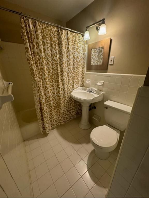 bathroom featuring tile walls, tile patterned floors, toilet, and shower / bath combo with shower curtain