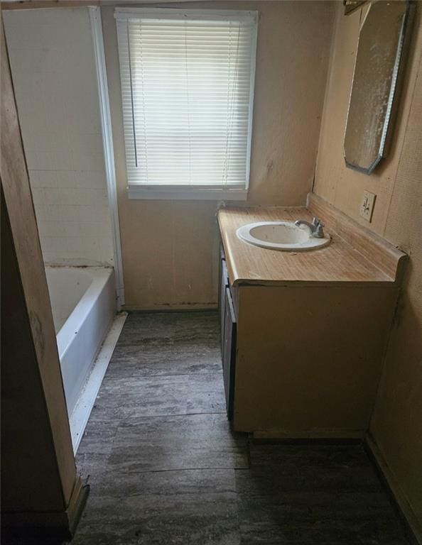 bathroom featuring hardwood / wood-style flooring, vanity, and a bathing tub