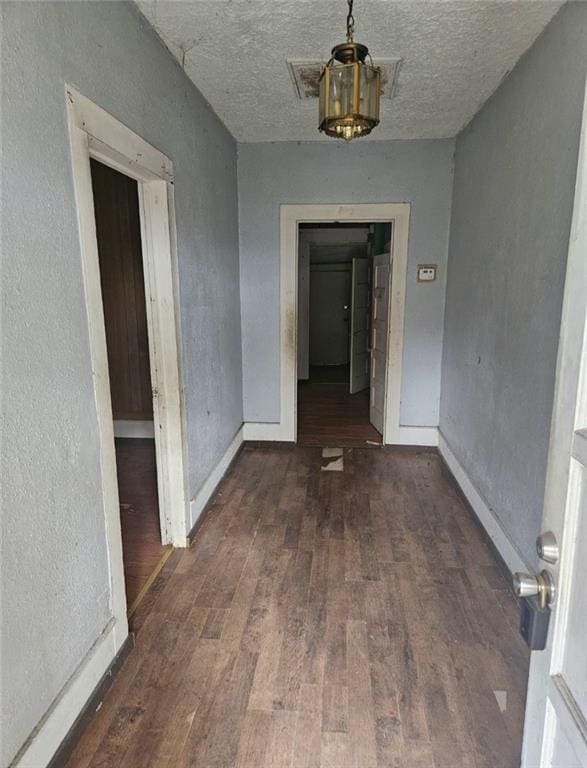 hallway featuring a textured ceiling and dark wood-type flooring