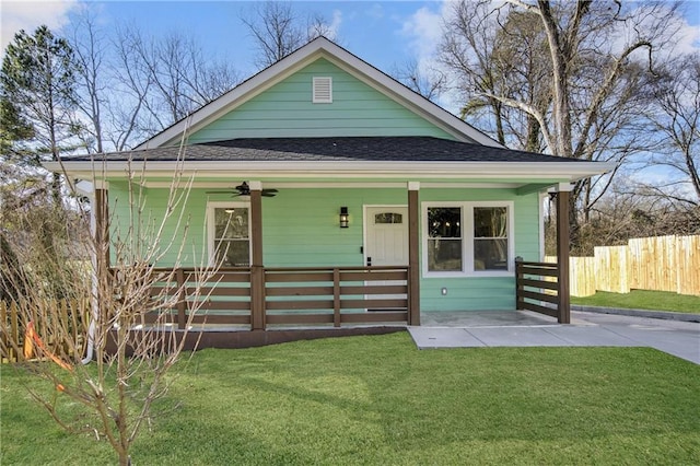 view of front of home with ceiling fan and a front yard