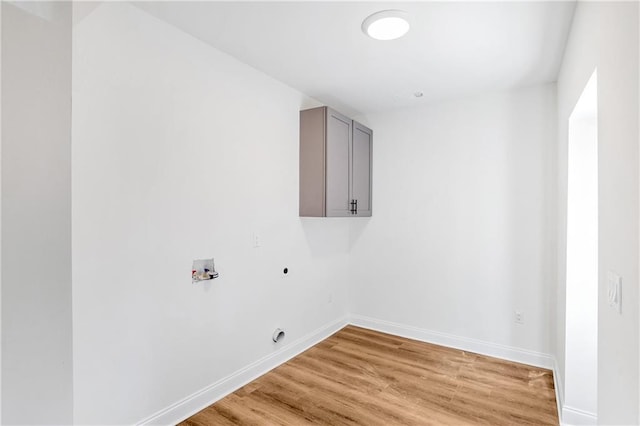 clothes washing area featuring washer hookup, cabinets, light hardwood / wood-style floors, and electric dryer hookup