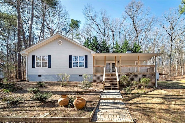 view of front of house with a chimney, french doors, crawl space, and a porch