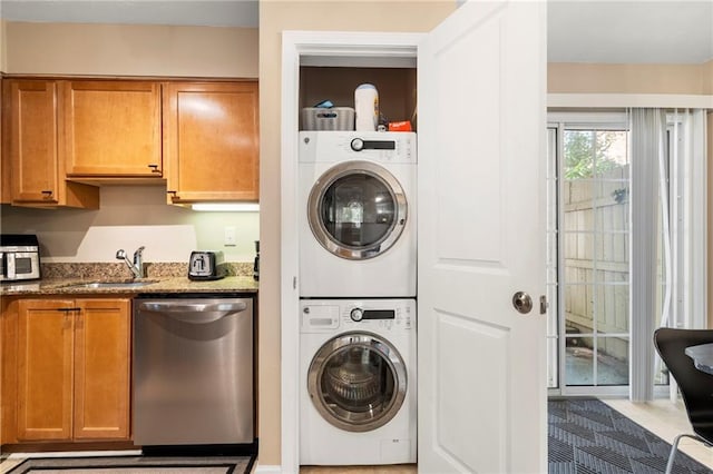 clothes washing area featuring stacked washer / drying machine, light tile patterned flooring, and sink