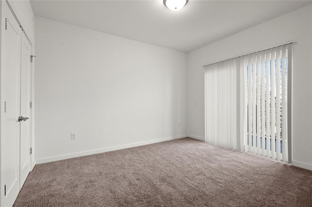 unfurnished bedroom featuring carpet and baseboards