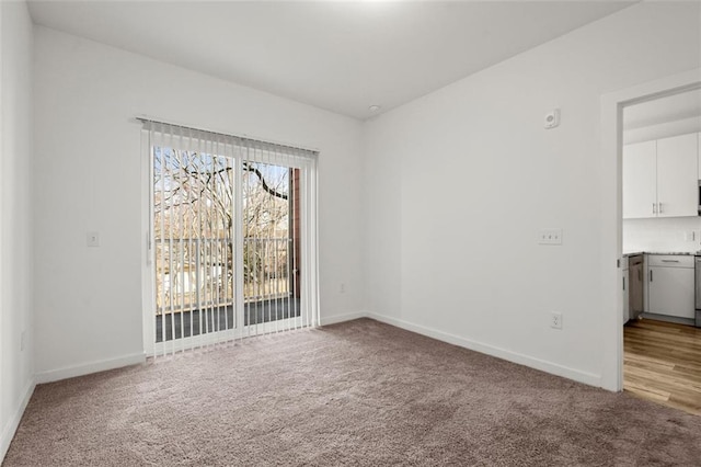 unfurnished room featuring light colored carpet and baseboards