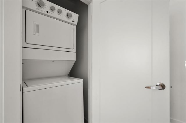 clothes washing area featuring laundry area and stacked washing maching and dryer