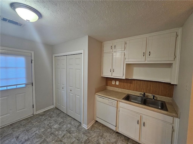 kitchen with dishwasher, sink, white cabinets, and a textured ceiling