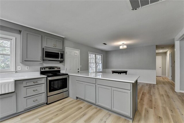 kitchen with gray cabinetry, sink, and appliances with stainless steel finishes