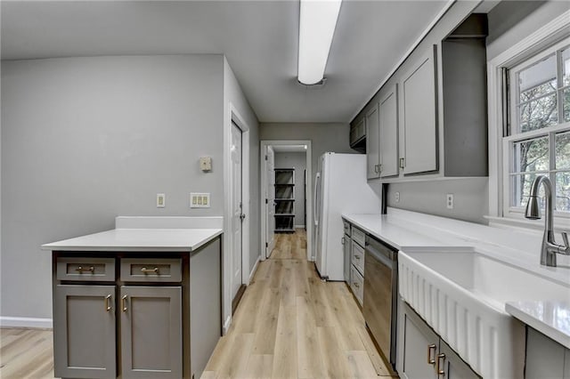 kitchen featuring gray cabinetry, dishwasher, sink, light wood-type flooring, and white fridge