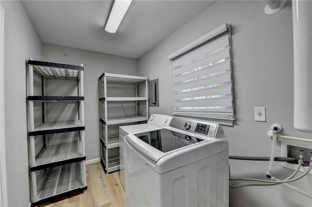 laundry area featuring washer and clothes dryer and light hardwood / wood-style floors