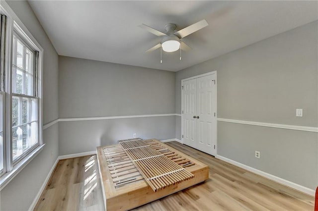 unfurnished bedroom featuring light hardwood / wood-style flooring, a closet, and ceiling fan