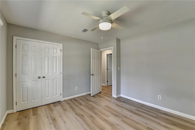 unfurnished bedroom with light wood-type flooring, a closet, and ceiling fan