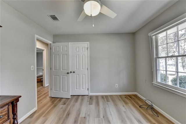 bedroom with multiple windows, a closet, ceiling fan, and light hardwood / wood-style floors