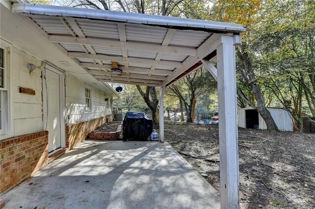 view of patio with ceiling fan, a grill, and a storage shed