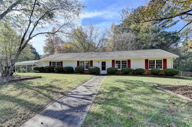 ranch-style home featuring a front yard and a carport