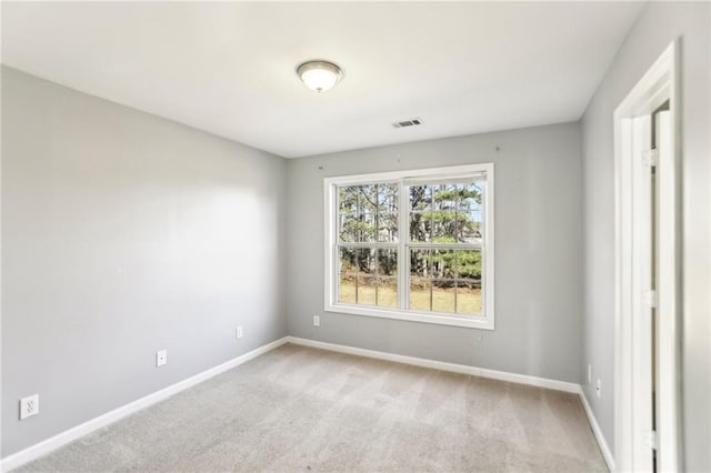 empty room featuring visible vents, baseboards, and light carpet