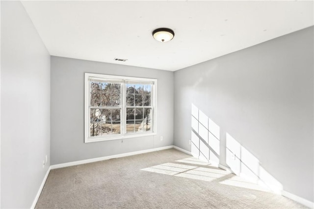 carpeted spare room featuring visible vents and baseboards