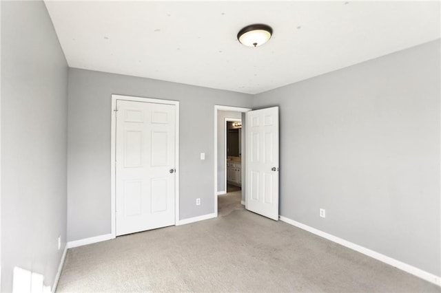 unfurnished bedroom with baseboards and carpet