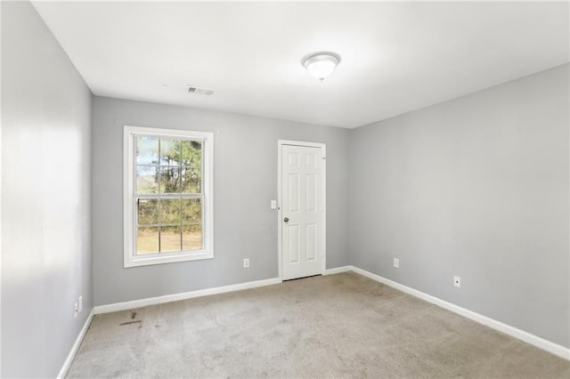 carpeted empty room with visible vents and baseboards