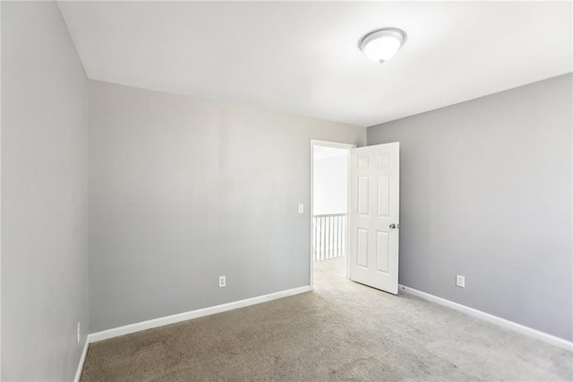 carpeted empty room featuring baseboards