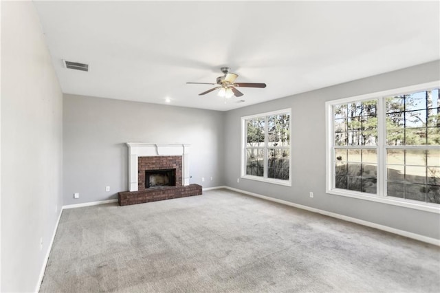 unfurnished living room with visible vents, carpet flooring, a fireplace, baseboards, and ceiling fan